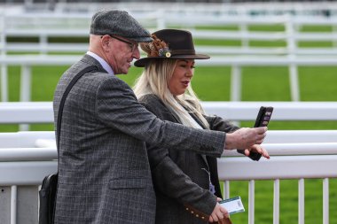 Yarışa katılanlar, 11 Nisan 202 'de İngiltere, Liverpool' daki Aintree Yarış Pisti 'nde düzenlenen Randox Grand National 2024 Açılış Günü' nde selfie çekiyorlar.