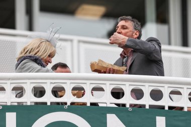 Yarışçılar, 11 Nisan 202 'de İngiltere, Liverpool' daki Aintree Yarış Pisti 'nde düzenlenen Randox Grand National 2024 Açılış Günü' nde bir şeyler atıştıracaklar.