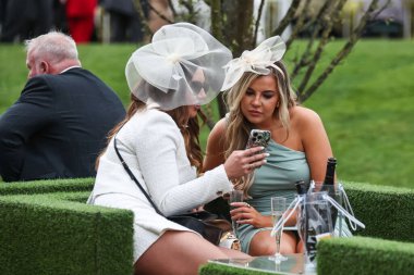 Yarışçılar, Aintree Yarış Pisti, Liverpool, İngiltere 'de düzenlenen Randox Grand National 2024 Bayanlar Günü' nde içki içiyorlar.