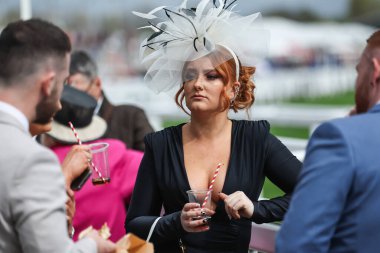 Yarışçılar, Aintree Yarış Pisti, Liverpool, İngiltere 'de düzenlenen Randox Grand National 2024 Bayanlar Günü' nde içki içiyorlar.
