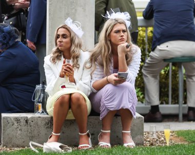 Yarışçılar, Aintree Yarış Pisti, Liverpool, İngiltere 'de düzenlenen Randox Grand National 2024 Bayanlar Günü' nde içki içiyorlar.