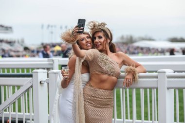 Yarışçılar, Aintree Yarış Pisti, Liverpool, İngiltere 'de düzenlenen Randox Grand National 2024 Bayanlar Günü' nde atmosferin keyfini çıkarıyorlar.