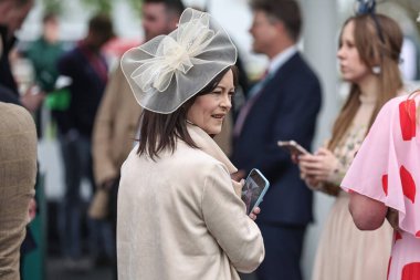 Yarışçılar, Aintree Yarış Pisti, Liverpool, İngiltere 'de düzenlenen Randox Grand National 2024 Bayanlar Günü' nde atmosferin keyfini çıkarıyorlar.