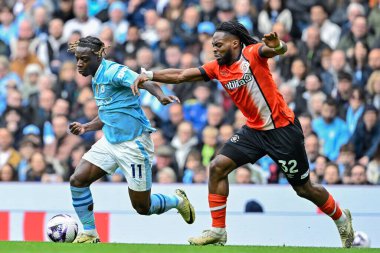 Manchester City 'den Jrmy Doku ve Luton Town' dan Fred Onyedinma Premier Lig karşılaşmasında Manchester City, Manchester, İngiltere 'deki Etihad Stadyumu' nda 13 Nisan 2024 tarihinde Luton Town 'a karşı oynadılar.