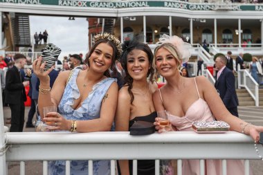Yarışçılar, Aintree Yarış Pisti, Liverpool, İngiltere 'de düzenlenen Randox Grand National 2024 Bayanlar Günü' nde atmosferin keyfini çıkarıyorlar.