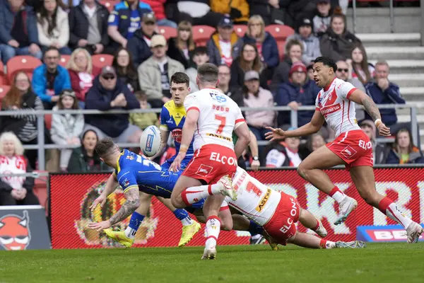 stock image Connor Wrench of Warrington Wolves off loads the ball to Josh Thewlis of Warrington Wolves during the Betfred Challenge Cup Quarter Final match St Helens vs Warrington Wolves at Totally Wicked Stadium, St Helens, United Kingdom, 14th April 202