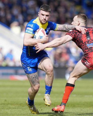 Warrington Wolves 'tan Connor Wrench, 20 Nisan 202' de Warrington, İngiltere 'deki Halliwell Jones Stadyumu' nda oynanan 8. Betfred Süper Lig karşılaşmasında Leopards 'dan Frankie Halton' a koşuyor.