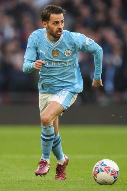 Manchester City 'den Bernardo Silva, 20 Nisan 202' de İngiltere 'nin Wembley Stadyumu' nda oynanan ve Manchester City 'nin Chelsea' ye karşı oynadığı Emirates FA Cup yarı final maçında topla birlikte ilerliyor.