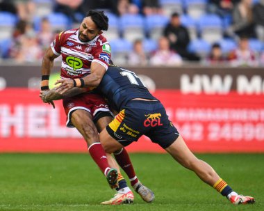 Bevan French of Wigan Warriors is tackled late by Tariq Sims of Catalan Dragons during the Betfred Super League Round 10 match Wigan Warriors vs Catalans Dragons at DW Stadium, Wigan, United Kingdom, 2nd May 2024  clipart
