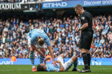 Manchester City 'den Erling Haaland ve Manchester City' den hakem Craig Pawson Premier League maçında Manchester City ile Manchester, İngiltere 'deki Etihad Stadyumu' nda Wolverhampton Wanderers maçında sakatlandıktan sonra Manchester City 'den Manuel Akanji' yi kontrol ediyorlar.