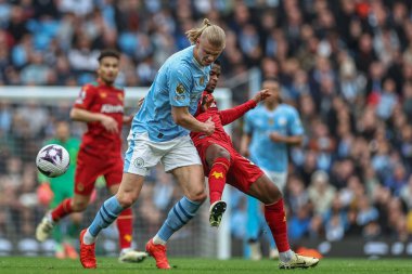 Manchester City 'den Erling Haaland, Premier League maçında Wolverhampton Wanderers' dan Nlson Semedo 'yu, Manchester, İngiltere' deki Etihad Stadyumu 'nda, 4 Mayıs 2024' te Wolverhampton Wanderers 'a karşı toptan çıkardı.