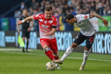 Barnsley 'den Nicky Cadden ve Bolton Wanderers takımından Josh Dacres-Cogley, 7 Mayıs 2024' te İngiltere 'deki Toughsheet Community Stadyumu' nda Bolton Wanderers 'ın Barnsley' e karşı oynadığı yarı final yarı final yarı final maçında top için mücadele ediyorlar.