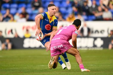 Warrington Wolves 'tan George Williams, Hull KR' dan Peta Hiku 'nun 9 Mayıs 2024' te Halliwell Jones Stadyumu 'nda oynanan 11. Betfred Süper Lig karşılaşmasında yaptığı baskıya rağmen pas veriyor.
