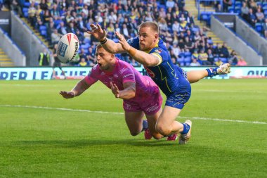 Warrington Wolves takımından Matt Dufty, 9 Mayıs 2024 'te Warrington, Warrington' da oynanan Betfred Süper Lig karşılaşmasında Hull KR 'dan Mikey Lewis' in önünde topu yere atmayı başaramadı.