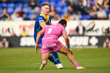 Warrington Wolves 'tan George Williams, Hull KR' dan Peta Hiku 'nun 9 Mayıs 2024' te Halliwell Jones Stadyumu 'nda oynanan 11. Betfred Süper Lig karşılaşmasında yaptığı baskıya rağmen pas veriyor.
