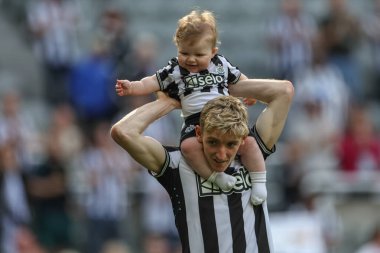 Anthony Gordon of Newcastle United with his child after the game during the Premier League match Newcastle United vs Brighton and Hove Albion at St. James's Park, Newcastle, United Kingdom, 11th May 2024  clipart