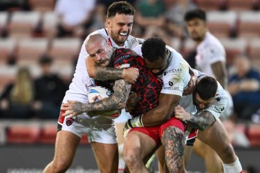 Zak Hardaker tackled by King Vuniyayawa, Cade Cust of Salford Red Devils and Oli Partington of Salford Red Devils during the Betfred Super League Round 11 match Leigh Leopards vs Salford Red Devils at Leigh, United Kingdom, 10th May 2024  clipart