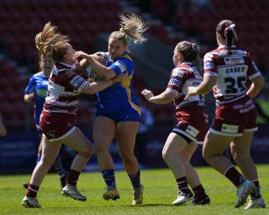 Grace Field of Leeds Rhinos, Wicked Stadyumu 'nda 19 Mayıs 2024' te oynanan Betfred Kadınlar Yarışma Kupası yarı final karşılaşmasında Wigan Warriors 'a karşı Wicked Stadyumu' nda Wigan Warriors 'un savunmasında koşuyor.