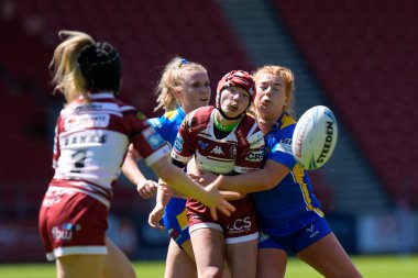 Wigan Warriors takımından Isabel Rowe, 19 Mayıs 2024 'te Wicked Stadyumu, St Helens, İngiltere' de oynanan Betfred Kadınlar Yarışma Kupası yarı final karşılaşmasında Grace Banks 'e pas veriyor.