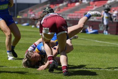 Leeds Rhinos takımından Caitlin Beevers, 19 Mayıs 2024 'te Wicked Stadyumu, St Helens, Birleşik Krallık' ta oynanan Betfred Kadınlar Yarıfinal karşılaşmasında Wigan Warriors karşısında gol atmak için Wigan Warriors defansına giriyor.