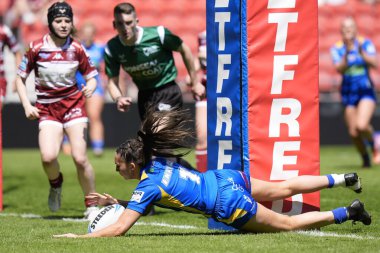 Leeds Rhinos takımından Ruby Enright, 19 Mayıs 2024 'te St Helens, İngiltere' deki Wicked Stadyumu 'nda oynanan Betfred Kadınlar Yarıfinal karşılaşmasında gol atmak için çizgiyi geçiyor.