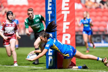 Leeds Rhinos takımından Ruby Enright, 19 Mayıs 2024 'te St Helens, İngiltere' deki Wicked Stadyumu 'nda oynanan Betfred Kadınlar Yarıfinal karşılaşmasında gol atmak için çizgiyi geçiyor.