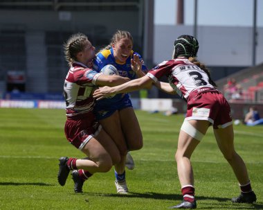 Leeds Rhinos takımından Caitlin Beevers, 19 Mayıs 2024 'te Wicked Stadyumu, St Helens, Birleşik Krallık' ta oynanan Betfred Kadınlar Yarıfinal karşılaşmasında Wigan Warriors karşısında gol atmak için Wigan Warriors defansına giriyor.