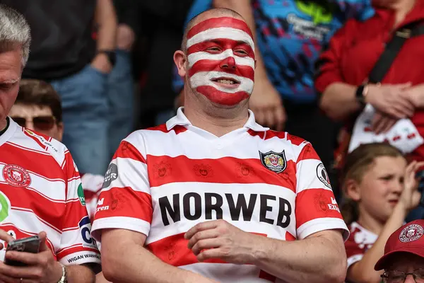 Wigan taraftarı, 18 Mayıs 2024 'te İngiltere' nin Doncaster kentindeki Eco-Power Stadyumu 'nda oynanan Betfred Challenge Kupası Yarı-Final Hull KR v Wigan Warriors maçında kiraz ve beyaz yüz boyası kullanmıştır.