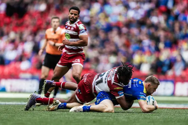stock image Matt Dufty of Warrington Wolves is tackled by Junior Nsemba of Wigan Warriors during the Betfred Challenge Cup Final match Warrington Wolves vs Wigan Warriors at Wembley Stadium, London, United Kingdom, 8th June 2024 