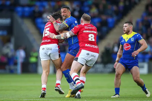 stock image Paul Vaughan is tackled by Shane Wright and Brad Singleton of Salford Red Devils during the Betfred Super League Round 14 match Warrington Wolves vs Salford Red Devils at Halliwell Jones Stadium, Warrington, United Kingdom, 14th June 2024 