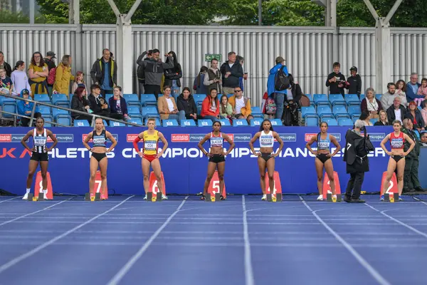 stock image Women prepare for the first Heat of the 100m during the Microplus UK Athletics Championships Day 1 at Manchester Regional Arena, Manchester, United Kingdom, 29th June 2024 