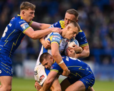 Leeds Rhinos 'tan Ash Handley, Warrington Wolves' un oynadığı 17. Warrington Wolves - Leeds Rhinos maçında Danny Walker ve Ben Currie tarafından, 11 Temmuz 2024 'te Halliwell Jones Stadyumu' nda yenildi. 