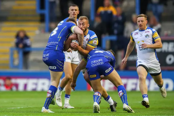 Warrington Wolves 'tan Matty Nicholson ve George Williams, Leeds Rhinos' tan Jarrod OConnor 'ı 17. Betfred Süper Ligi karşılaşmasında yendi. Warrington Wolves, Leeds Rhinos' a karşı Halliwell Jones Stadyumu, Warrington, İngiltere, 11 Temmuz 2024