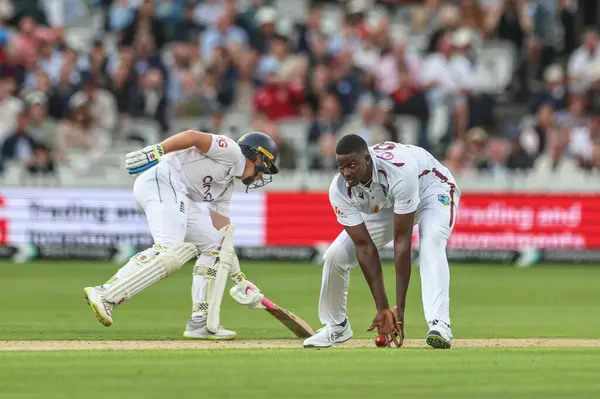 stock image Jason Holder of West Indies fields his own ball off Zak Crawley of England during the 1st Rothesay Test Match day 1 England v West Indies at Lords, London, United Kingdom, 10th July 2024 