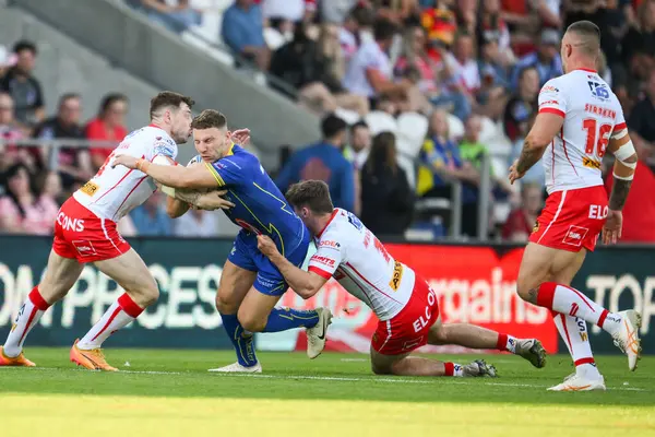 stock image George Williams is tackled by Lewis Dodd of St. Helens and Mark Percival of St. Helens during the Betfred Super League Round 18 match St Helens vs Warrington Wolves at Totally Wicked Stadium, St Helens, United Kingdom, 19th July 2024