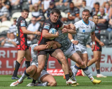 Matt Whitley of St. Helens is tackled by Morgan Smith of Hull FC, Will Gardiner of Hull FC and Ed Chamberlain of Hull FC during the Betfred Super League Round 20 match Hull FC vs St Helens at MKM Stadium, Hull, United Kingdom, 3rd August 2024 clipart