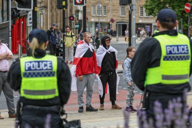 Irkçılık karşıtı protesto sırasında İngiltere bayrağına sarılmış protestocular, Barnsley, Birleşik Krallık, 8 Ağustos 2024
