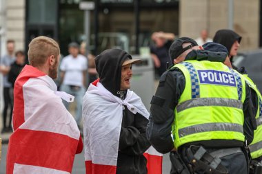 Polis, 8 Ağustos 2024 'te Barnsley, İngiltere' deki ırkçılık karşıtı protesto sırasında gösteri devam ederken kalabalıktaki insanlardan ayrıntıları almaya başladı.