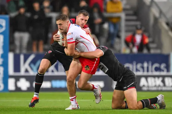 stock image Matty Lees tackled by Marc Sneyd of Salford Red Devils and Sam Stone of Salford Red Devils during the Betfred Super League Round 21 match St Helens vs Salford Red Devils at Totally Wicked Stadium, St Helens, United Kingdom, 8th August 2024