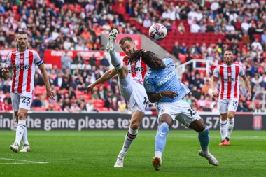 Stoke City 'den Ben Wilmot ve Coventry City' den Brandon Thomas-Asante, 10 Ağustos 2024 'te Stoke City ile Coventry City arasındaki maçta top mücadelesi verdiler.