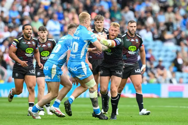 stock image Luke Thompson of Wigan Warriors fends off George Delaney of St. Helens during the Magic Weekend match Wigan Warriors vs St Helens at Elland Road, Leeds, United Kingdom, 17th August 2024