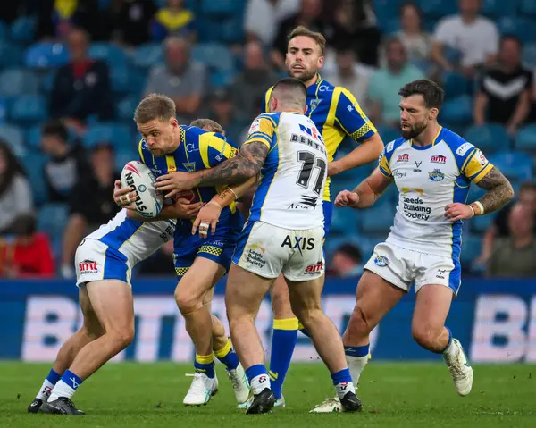 stock image Matt Dufty of Warrington Wolves is tackled by James Bentley of Leeds Rhinos and Jarrod OConnor of Leeds Rhinos during the Magic Weekend match Warrington Wolves vs Leeds Rhinos at Elland Road, Leeds, United Kingdom, 17th August 2024