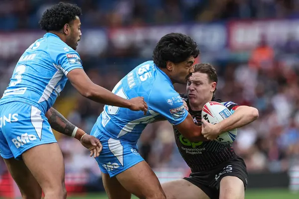 stock image Jai Field of Wigan Warriors is tackled by James Bell of St. Helens during the Magic Weekend match Wigan Warriors vs St Helens at Elland Road, Leeds, United Kingdom, 17th August 2024