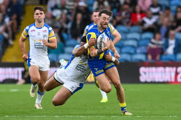 stock image Matty Ashton of Warrington Wolves is tackled by David Fusitua of Leeds Rhinos during the Magic Weekend match Warrington Wolves vs Leeds Rhinos at Elland Road, Leeds, United Kingdom, 17th August 2024