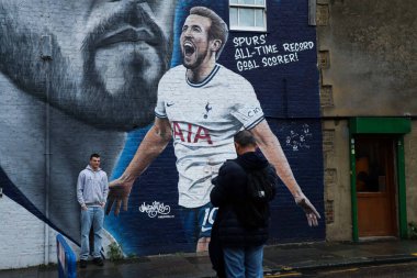 Tottenham taraftarları 24 Ağustos 2024 'te Tottenham Hotspur Stadyumu' nda oynanan Premier League maçından önce Harry Kane duvar resminin yanında poz verdiler.