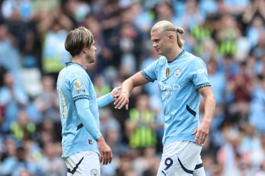 Manchester City 'den Jack Grealish, Manchester City' nin 24 Ağustos 2024 'te Etihad Stadyumu' nda oynanan Premier League maçı sırasında Manchester City 'nin Ipswich Town' a karşı oynadığı maçtan sonra Manchester City 'den Erling Haaland ile el sıkışıyor.