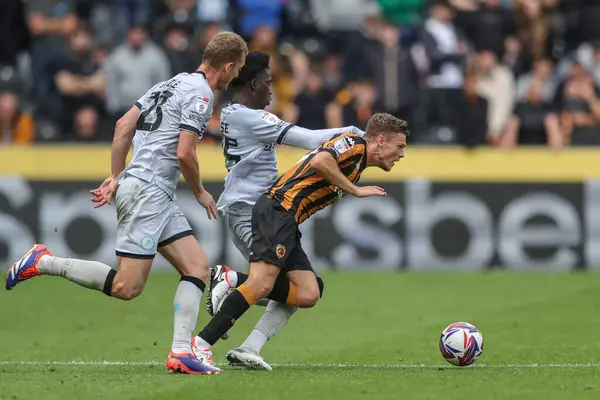 stock image Regan Slater of Hull City is fouled by Romain Esse of Millwall during the Sky Bet Championship match Hull City vs Millwall at MKM Stadium, Hull, United Kingdom, 24th August 2024