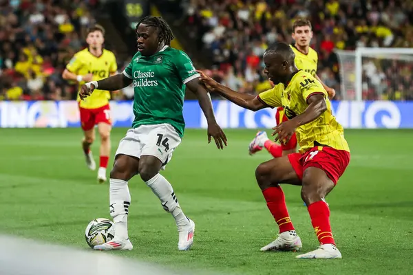 stock image Michael Obafemi of Plymouth Argyle is put under pressure by Edo Kayembe of Watford during the Carabao Cup match Watford vs Plymouth Argyle at Vicarage Road, Watford, United Kingdom, 27th August 2024