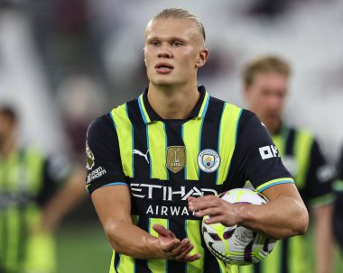 Erling Haaland of Manchester City applauds the traveling fans as the hat trick hero collects the match ball during the Premier League match West Ham United vs Manchester City at London Stadium, London, United Kingdom, 31st August 2024 clipart