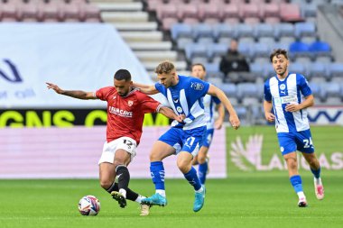 Morecambe 'den Kayden Harrack, Wigan Athletic takımından Scott Smith' i Bristol Street Motors Kupası 'nda Wigan Athletic' e karşı Morecambe maçı sırasında tutuyor.